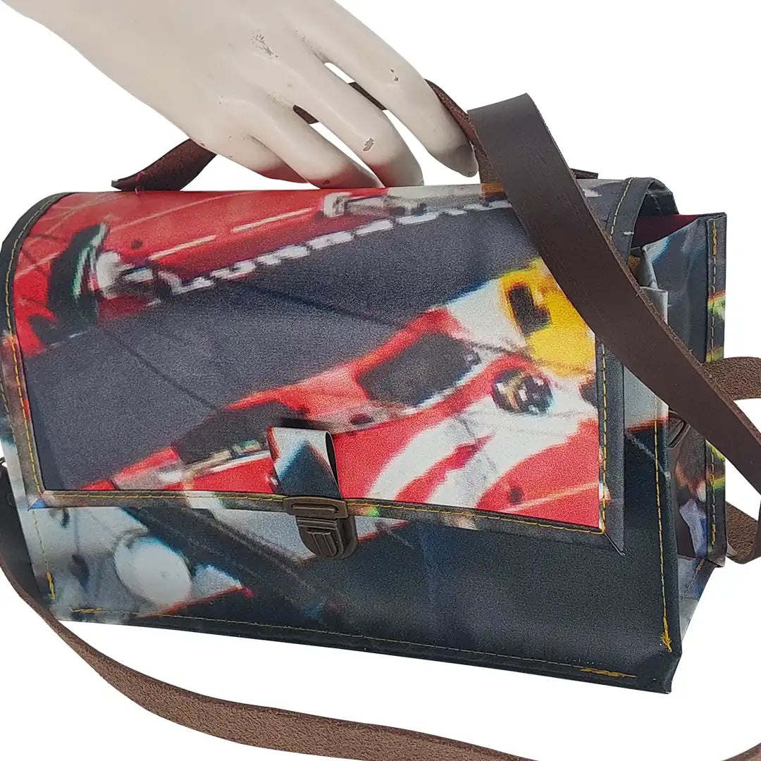 Alice Bag 224 by ReCreate, a structured bag in reclaimed advertising banner with red graphic fragments, leather strap and yellow zip. -detail