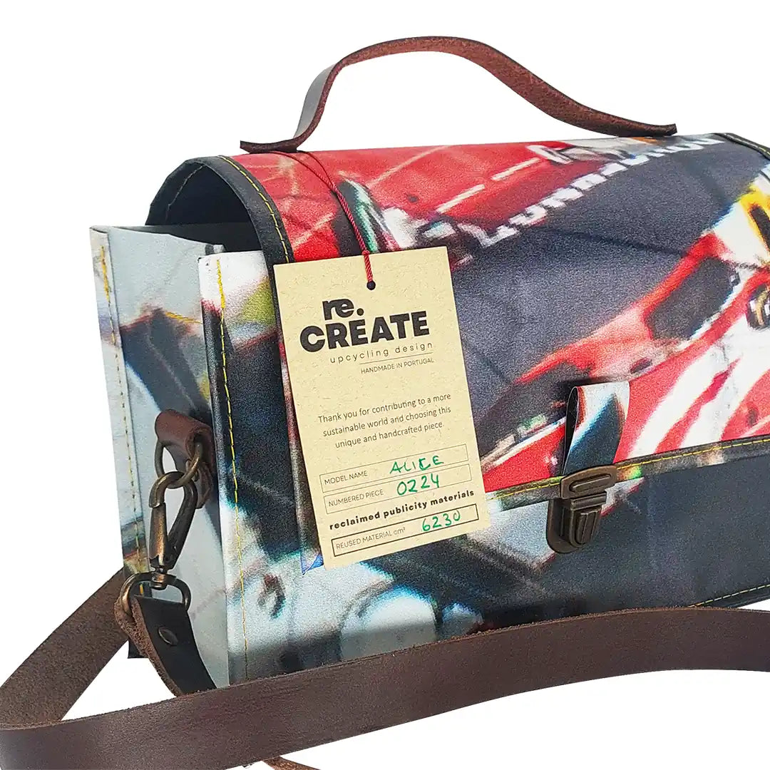 Alice Bag 224 by ReCreate, a structured bag in reclaimed advertising banner with red graphic fragments, leather strap and yellow zip. - tag