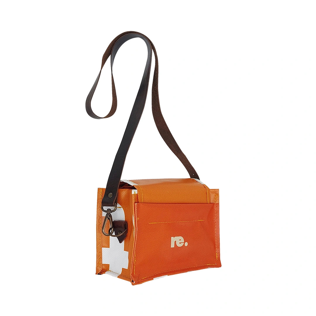 Anita Bag 424 by ReCreate, a compact orange bag in reclaimed advertising banner with bold white graphics, leather strap and metal clasp. -side
