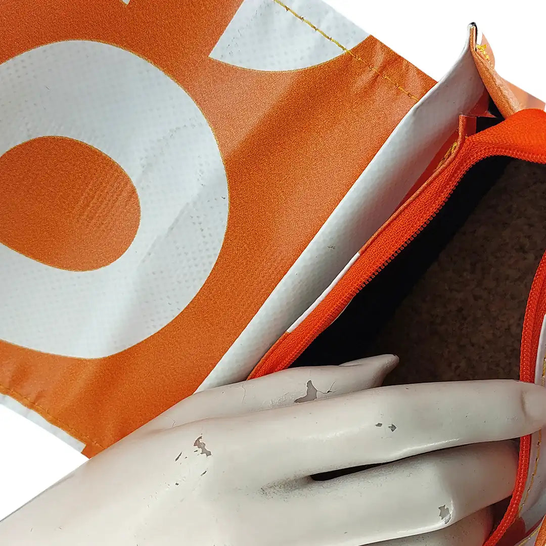 Anita Bag 424 by ReCreate, a compact orange bag in reclaimed advertising banner with bold white graphics, leather strap and metal clasp. - inside