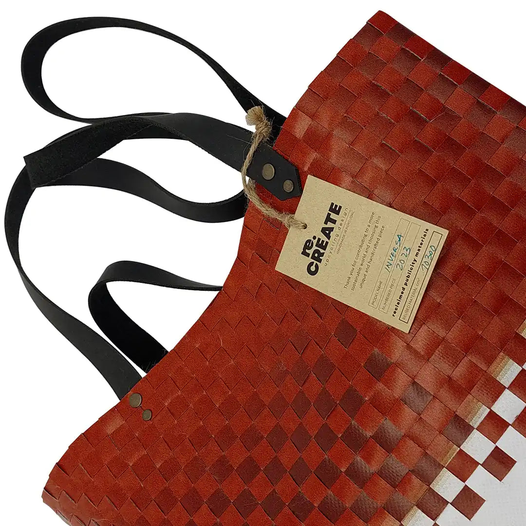 Inversa Bag 223 by ReCreate, a red and white tote in reclaimed advertising banner with inverted woven work, leather straps and one inner pocket.- tag