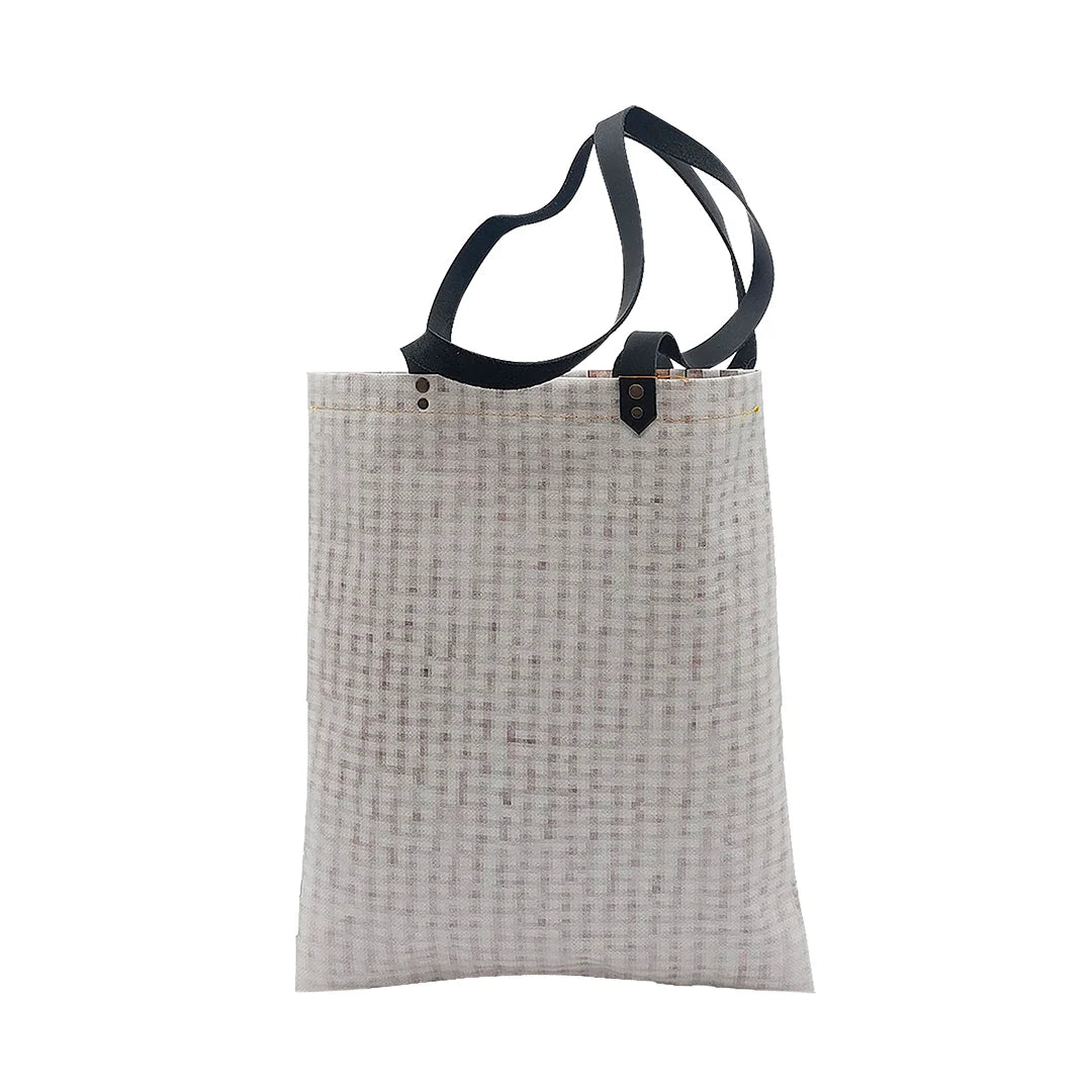 Rita Bag 1623 by ReCreate, a pale woven tote in reclaimed advertising banner with black leather straps and one inner pocket. - back