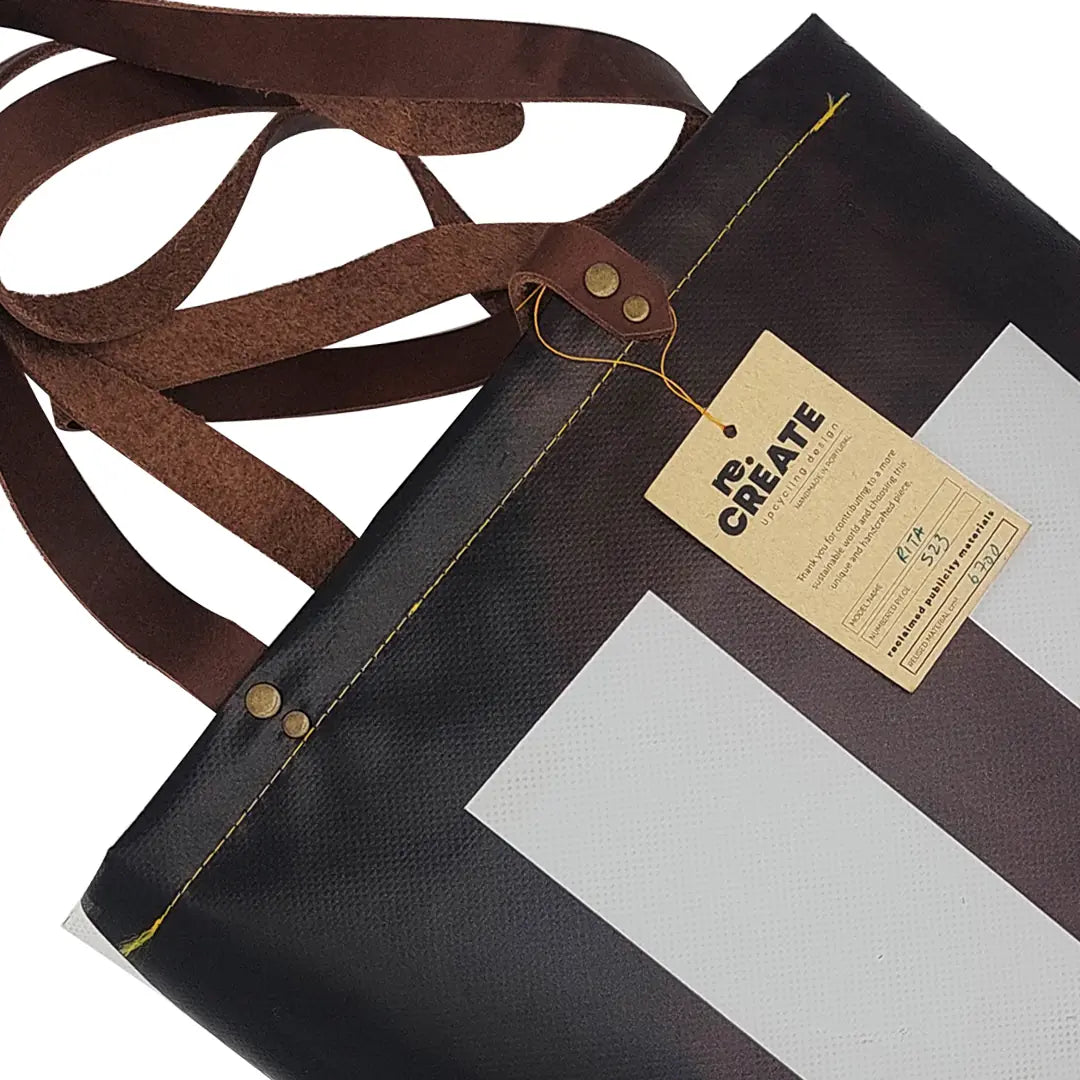 Rita Bag 523 by ReCreate, a black, white and red tote made from reclaimed advertising banner with leather straps and one inner pocket. - tag