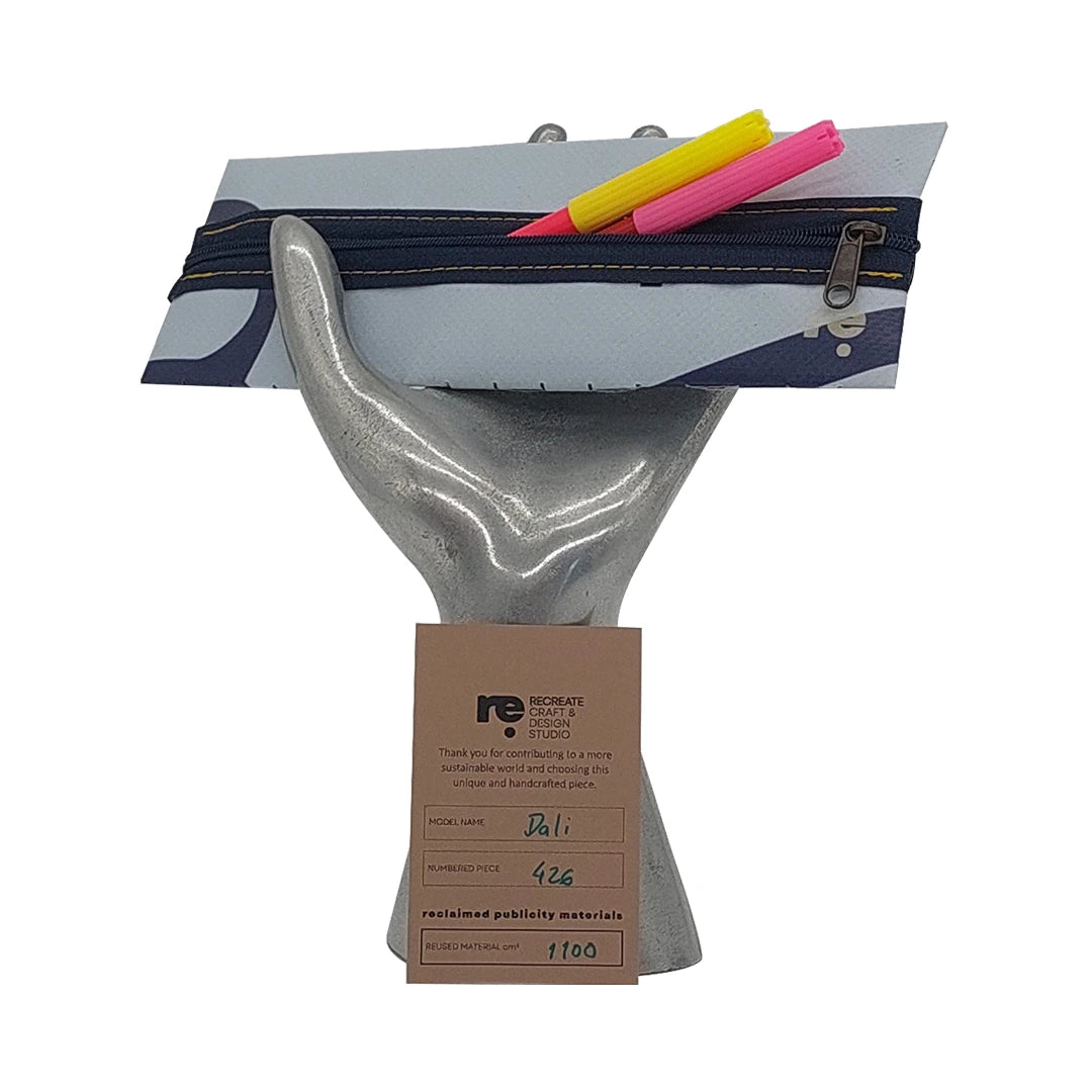 Slim pouch made from reclaimed advertising banner in soft blue and navy tones, ideal for pens, cables and everyday essentials. - on hand