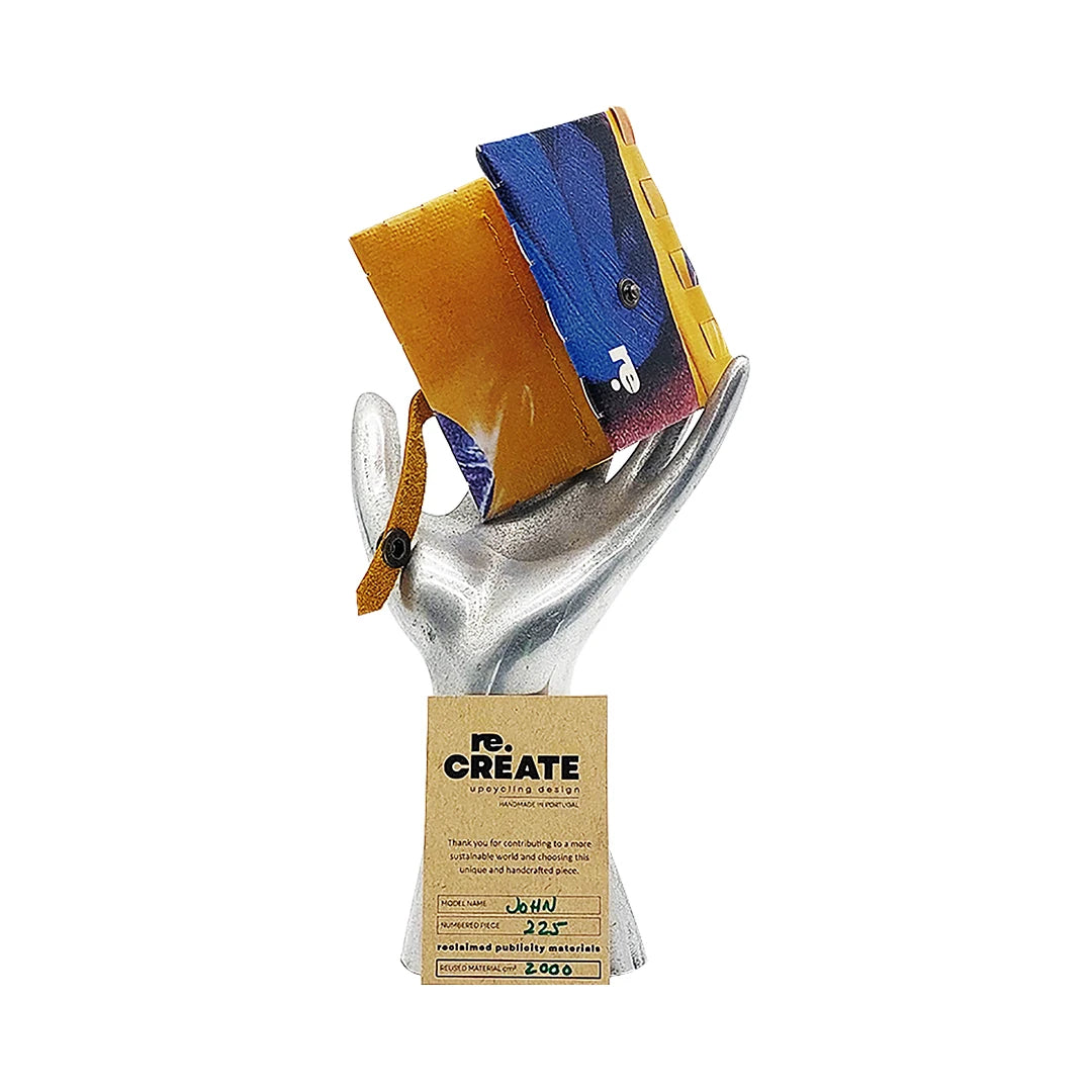 John Wallet 225 is a ReCreate wallet made from reclaimed advertising banner, with yellow-blue graphics, coin space and room for 8 cards. - on hand