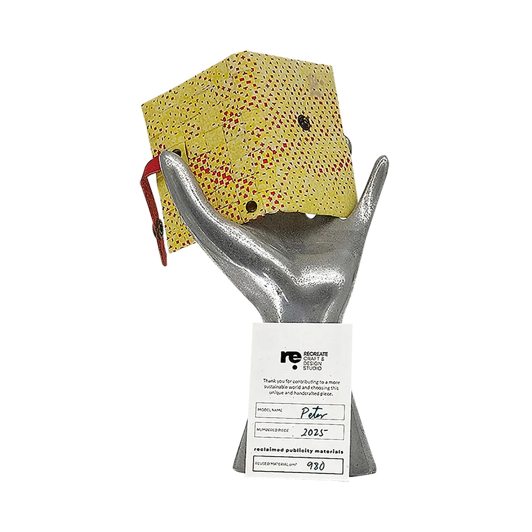 Peter Wallet 2025 is a ReCreate wallet made from reclaimed advertising banner, with red graphic marks, space for 6 cards and coins. - on hand