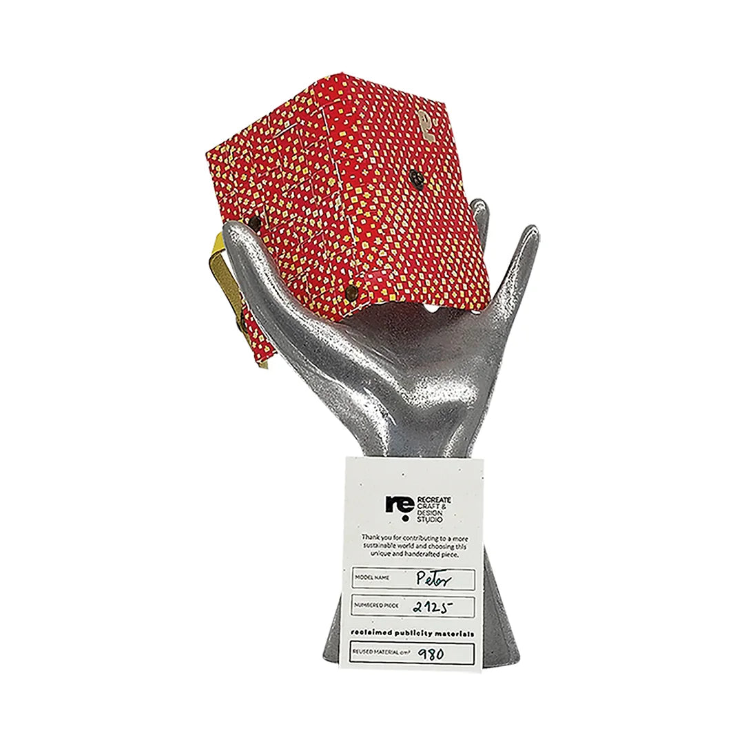 Peter Wallet 2125 by ReCreate is a red reclaimed-banner wallet with yellow graphic detail, designed to hold up to 6 cards and coins. - on hand