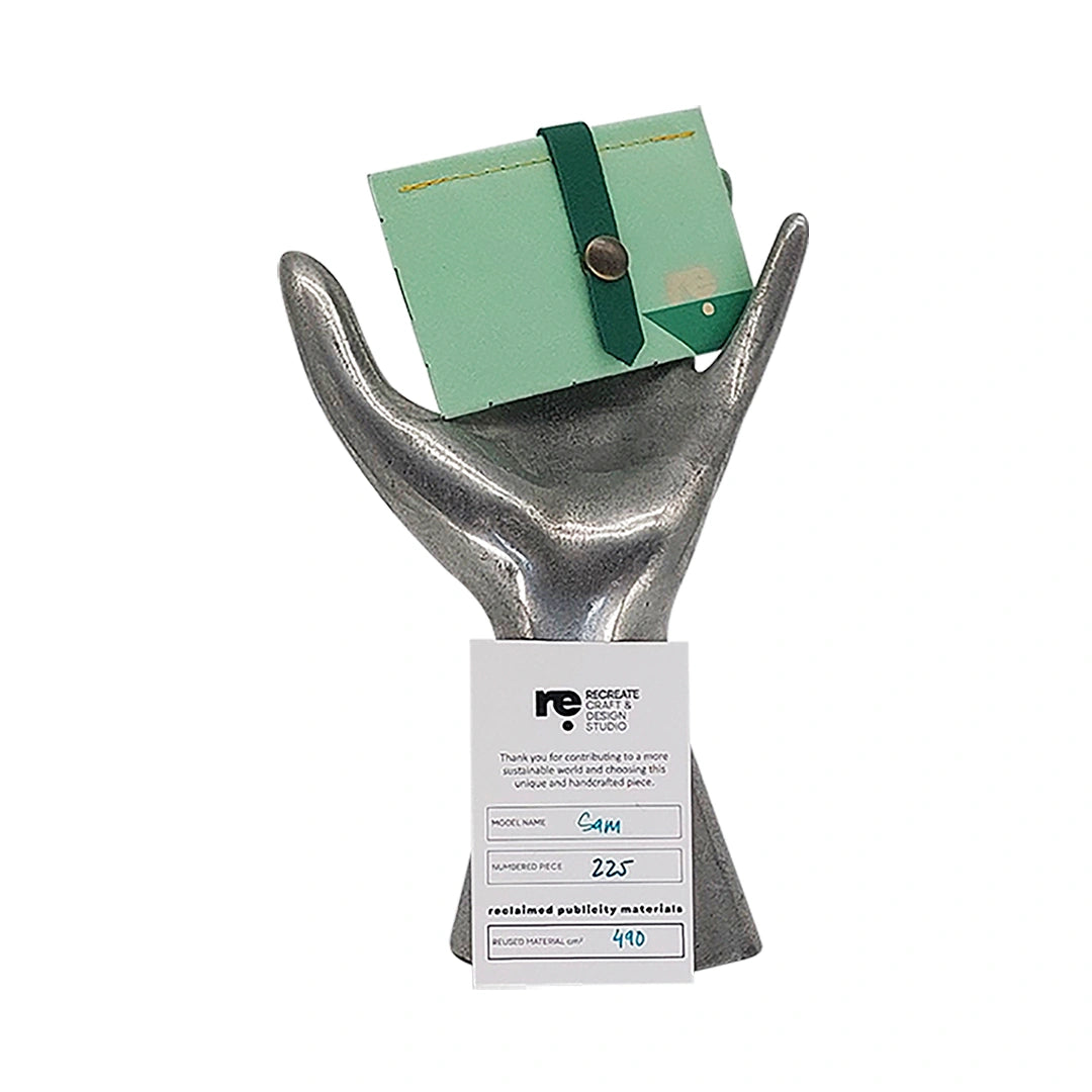 Sam Wallet 225 is a ReCreate wallet made from reclaimed advertising banner, with soft green tones, woven detail and space for up to 6 cards. - on hand