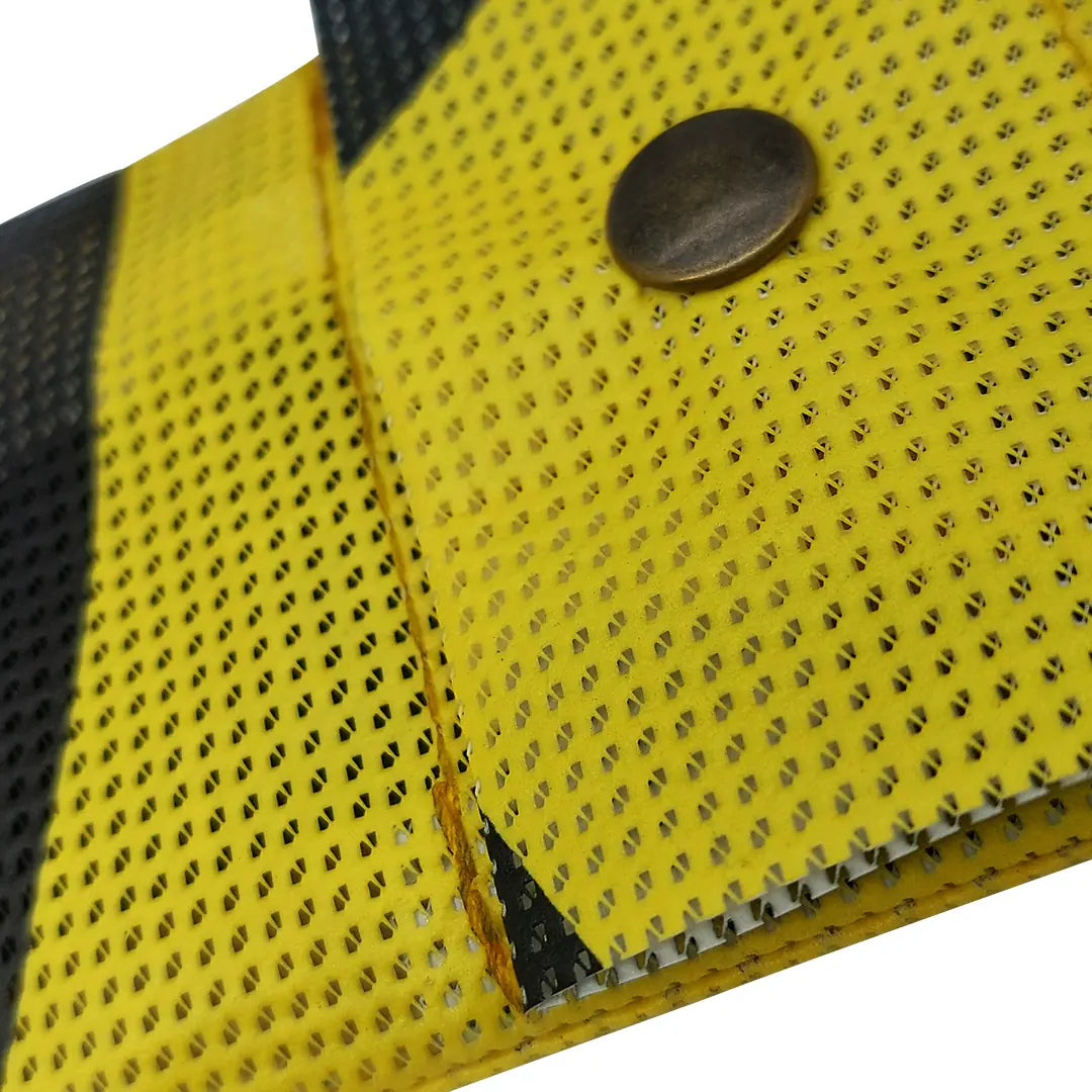 Yellow and black pouch made from reclaimed micro-perforated banner, designed to hold pencils, pens or slim everyday tools in a compact format.  detail