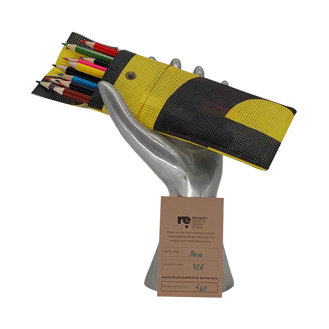 Yellow and black pouch made from reclaimed micro-perforated banner, designed to hold pencils, pens or slim everyday tools in a compact format. - with pensils