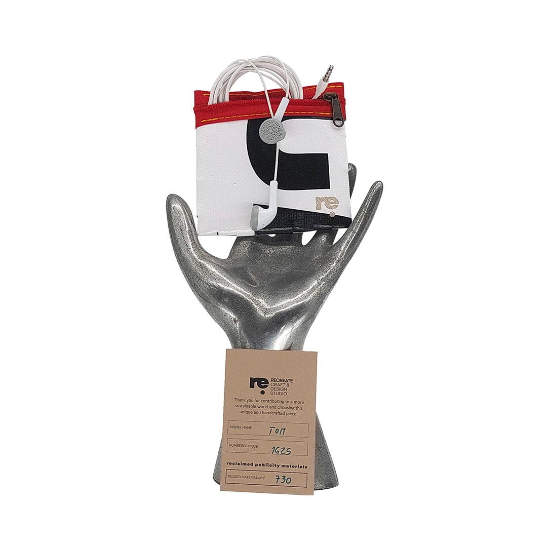 Tom Pouch 1625 is a ReCreate pouch made from reclaimed advertising banner, with black and white graphic shapes, red zip and woven back. - on hand